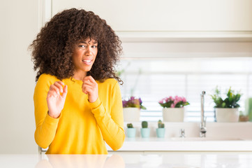 African american woman wearing yellow sweater at kitchen disgusted expression, displeased and...