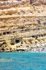 Matala beach with caves on the rocks that were used as a roman cemetery and at the decade of 70's were living hippies from all over the world, Crete, Greece