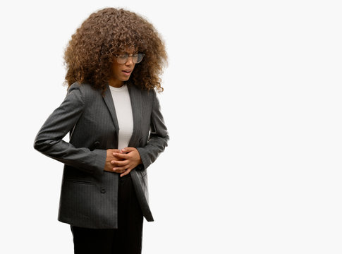 African american business woman wearing glasses with hand on stomach because indigestion, painful illness feeling unwell. Ache concept.