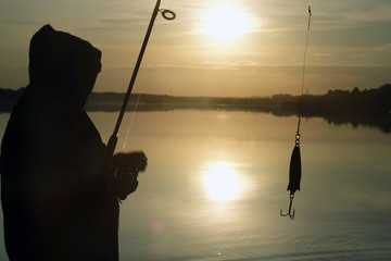 Fisherman silhouette at sunset. hobby, sport.