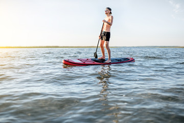 Man paddleboarding on the lake during the morning light