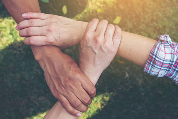 Group of young sport team hands together, team partners giving fist bump come together for sport battle outdoor. Corporate teamwork partnership. Meeting,business concept,vintage tone.