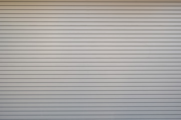 Obraz premium A closeup shot of automatic metal roller door used in factory, storage, garage, and industrial warehouse. The corrugated and foldable metal sheet offer space saving and provide urban and rustic feel