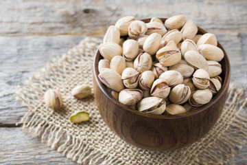 Delicious salted pistachios in a wooden bowl