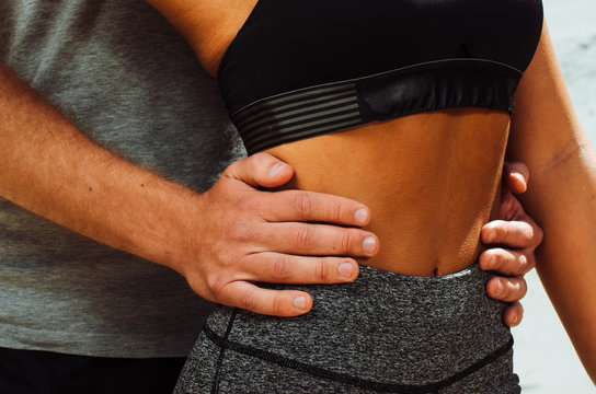 the guy holds the girl by the waist. frame closeup