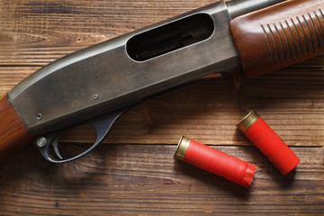 12 gauge pump action shotgun on wood detail and shells.