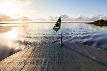 Amazonas , Brazil. View of the backside of a traditional boat with flag of Brazil in the Negro...