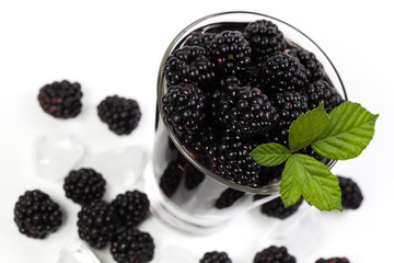 Blackberry with green leaves in a mug. View from above