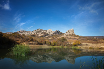 Landscape. The lake at the foot of the mountains against the blu