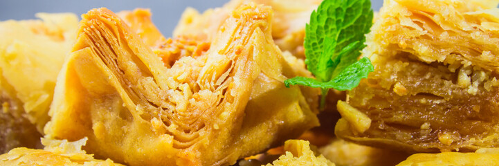Jewish, turkish, arabic traditional national dessert. Macro. Selective focus. Baklava with honey and nuts banner