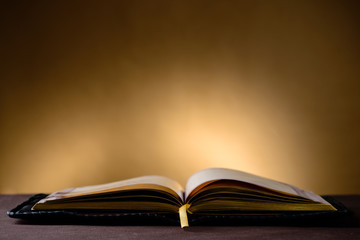 Still life with open old book on wooden table