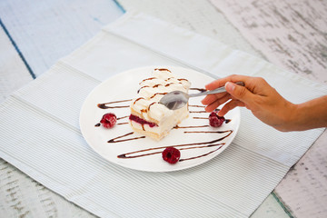 Try the dessert. The hand holds a spoon and breaks off a piece of cake
