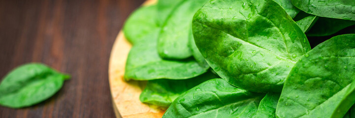 Fresh juicy spinach leaves on a wooden brown table. Natural products, greens, healthy food, vitamins. banner