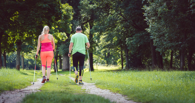 Couple of man and woman doing Nordic Walking for sport