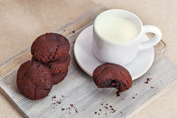 Chocolate cookies with milk on wooden desk. Sweet breakfast. Copy space. Top view.