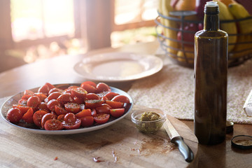 Fresh Cherry Tomatoes under oil and seasoning on the table, summer terrace