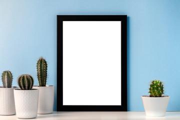 Empty mockup frame with groupe of cactuses on the background of the blue wall