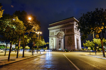 Naklejka premium Paris, France - August 9, 2017. Night view on Triumphal Arch at the center of Place Charles de Gaulle, on the top of Champs Elysees. Famous historical monument in Paris, popular touristic landmark.