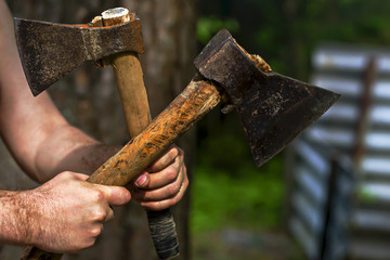 man holding axes in nature