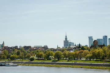Fototapeta premium City over the river. Warsaw over the Vistula. The old town is the Polish and Viennese Boulevards. Old and owen parts of the city. Architecture. Temples and churches. High-rise buildings and historic
