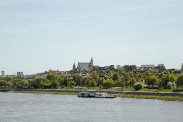 Obraz premium City over the river. Warsaw over the Vistula. The old town is the Polish and Viennese Boulevards. Old and owen parts of the city. Architecture. Temples and churches. High-rise buildings and historic
