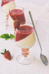 Panna cotta. Layered vanilla milk berry dessert. Pannacotta in glass with strawberry jello. Traditional italian dessert. Copy space.