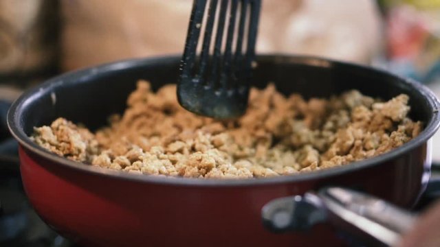 Cooking ground beef in pan and making enchiladas