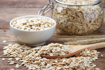 Dry rolled oat flakes oatmeal on wooden table