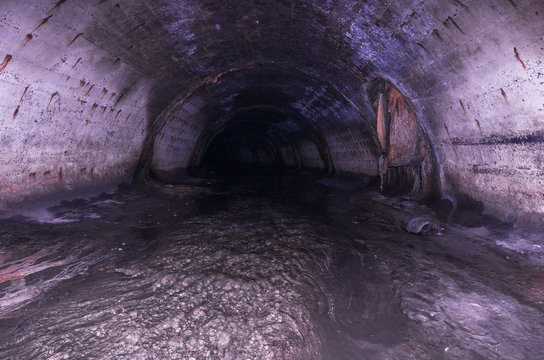 A narrow oval tunnel under the ground. Sewage road.