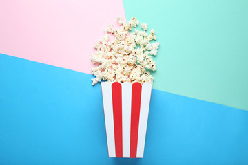 Popcorn in striped bucket on colorful background