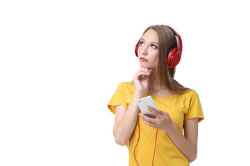 Young woman with headphones and smartphone on white background