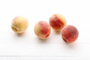 Ripe peaches fruit on white wooden table