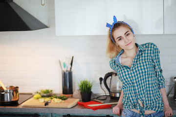 A cute young girl in the kitchen prepares food