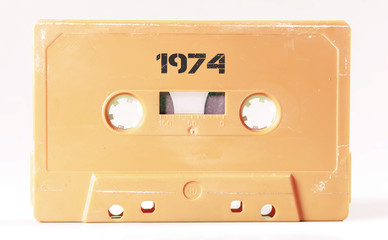 A vintage cassette tape from the 1980s era (obsolete music technology) with the text 1974 printed over it, stencil font. Color: cream, sand. White background.
 - obrazy, fototapety, plakaty
