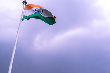 Indian national flag swaying in the wind against a cloudy sky on a full mast position. Showcasing the patriotism and national pride of the indian people