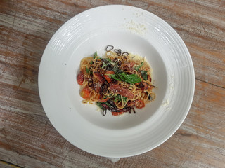 Gourmet tasty Italian spaghetti served  in white plate on the table background.