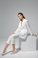 Young and beautiful model on a gray background. High fashion