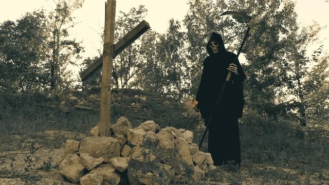 death with a scythe throws flowers at the grave of the one whom she took with her