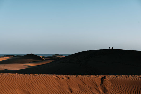 Couple sitting on top of Maspalomas Dunes on Gran Canaria during sunset