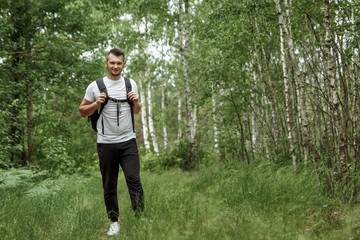 Portrait of a young man, a wanderer with a backpack. Goes on the road with a copy space, a happy...