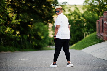 Stylish arabian muslim boy with originally hair and sunglasses posed on streets.