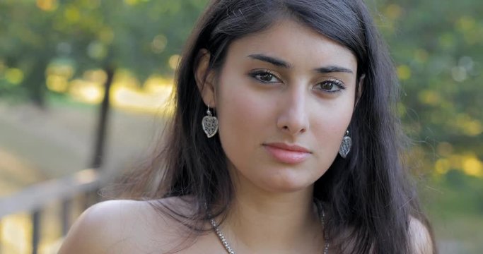 Beautiful young woman looks at camera flirting - outdoor