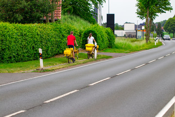 Postman riding his cargo bike carrying out mail in neighborhood