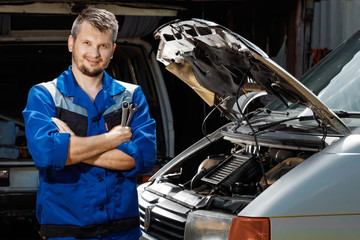 The auto mechanic works in the garage. Repair service. Maintenance of the car, car repair.