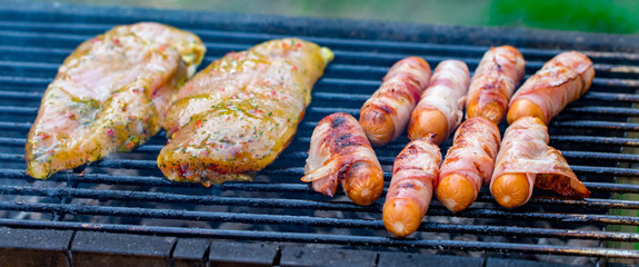 Assorted mixed grill from chicken meat, and pork, sausages  roasting on barbecue grid cooked for summer family dinner