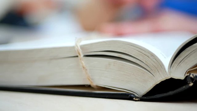 Woman's Hands Open The Book On The Table And Find Information