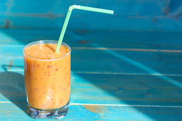 Fresh smoothies on a blue wooden background.