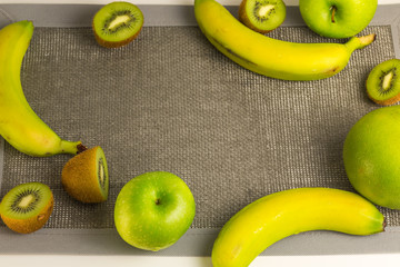 Variety of green fruits with empty gray fabric. The view from the top
