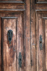 Fototapeta na wymiar Antique wooden front door with ornate knocker.