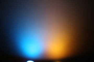 Lanterns of yellow and blue glow on a dark background